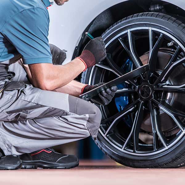 Mechanic inspecting tires and wheels